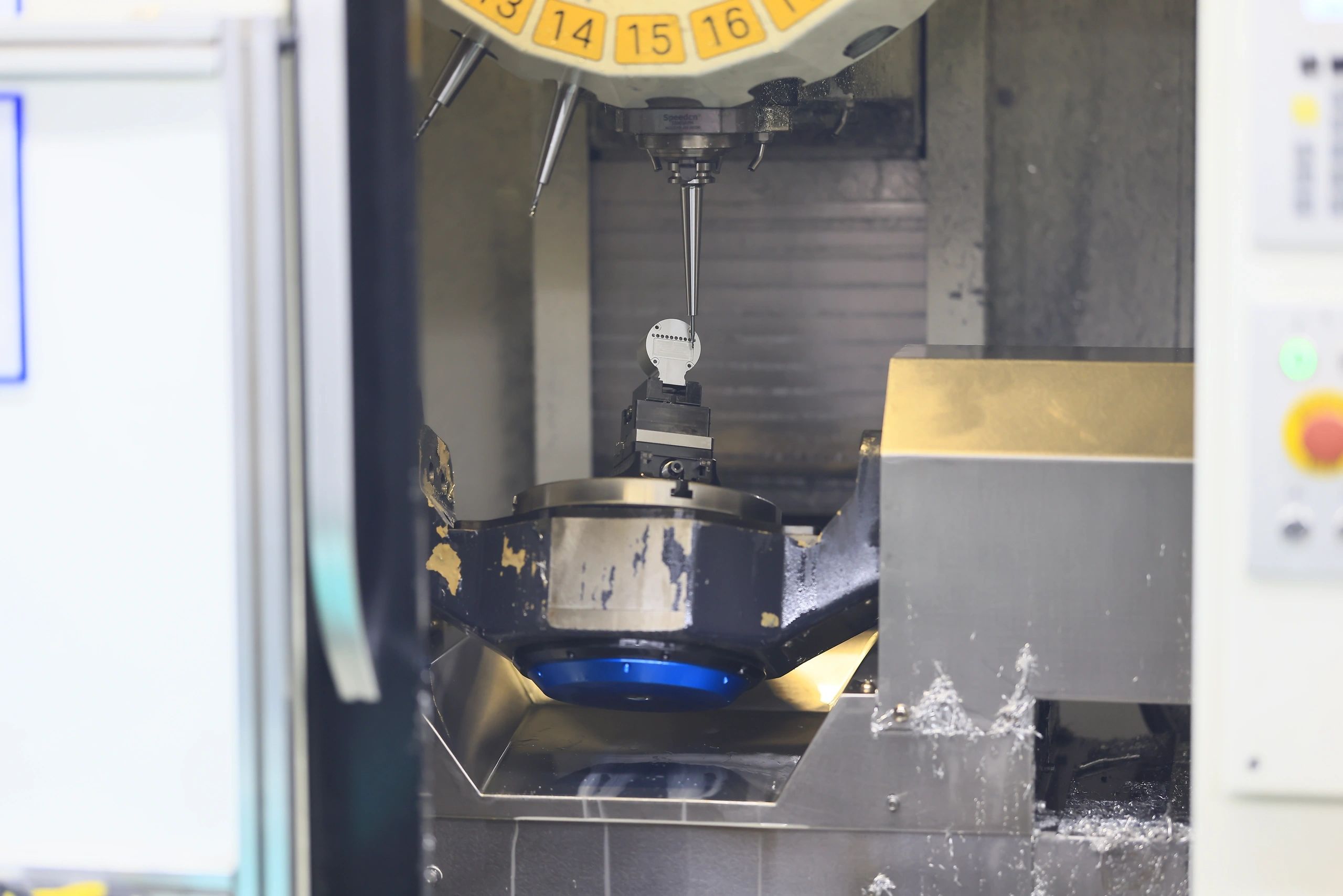 Blue anodized component under in-process 5-axis CMM inspection
