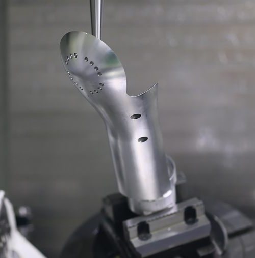 5-axis machined aluminium humanoid robot leg component on the trunnion table