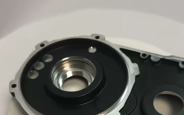 Black anodized aluminium gearbox housing half with bright bare-metal bearing bores and a bare sealing face